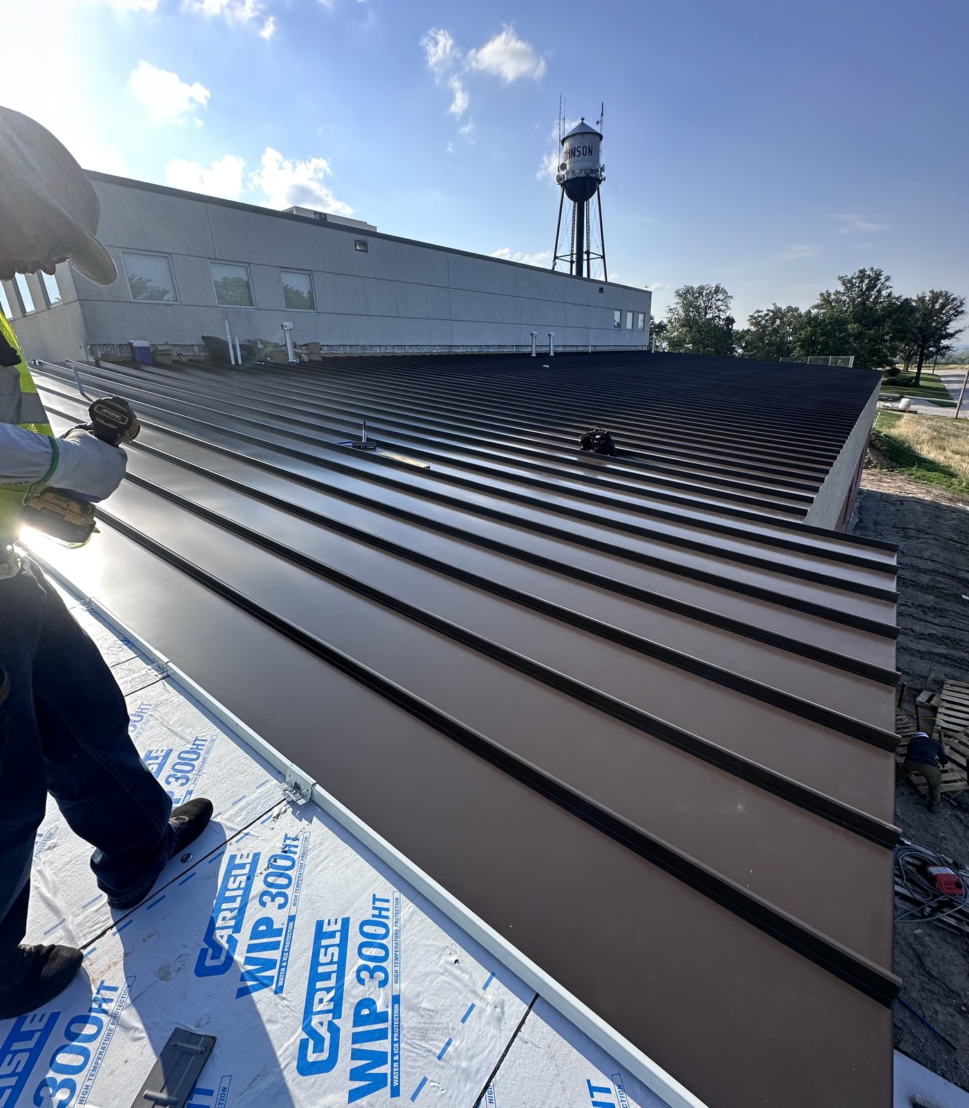 Flores Roofing crew installing standing seam metal roofing
